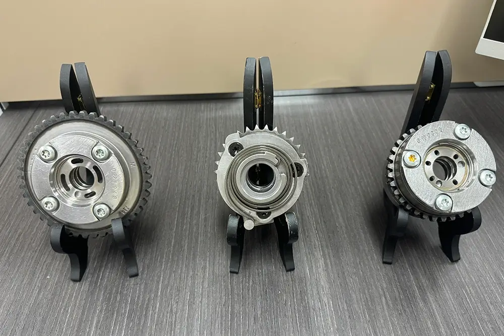 Camshaft phasers showing different centre bores, oil-port layouts and sprocket configurations for position matching