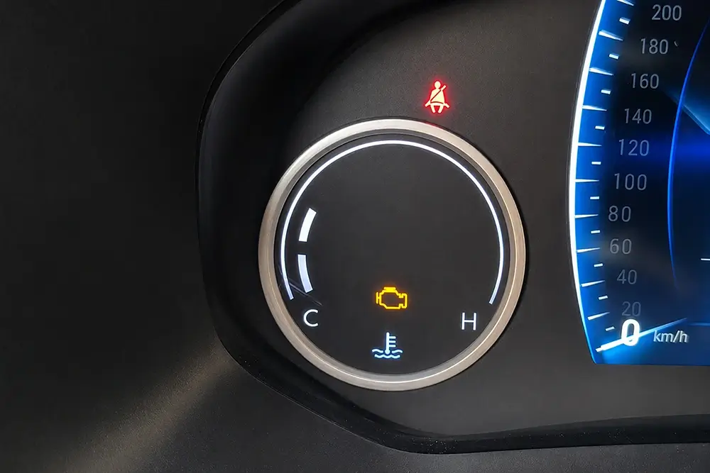 Dashboard coolant temperature and engine warning indicators associated with a cooling-system fault